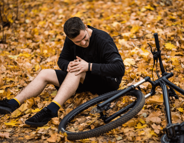 Mann hält sich das Knie nach einem Fahrradsturz