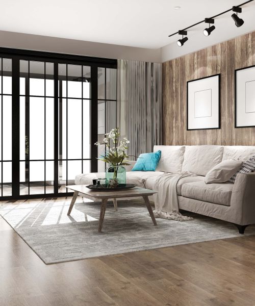 Ein Wohnzimmer, mit einer weißen Couch und einem Couchtisch auf dem eine Vase und Blumen stehen 
